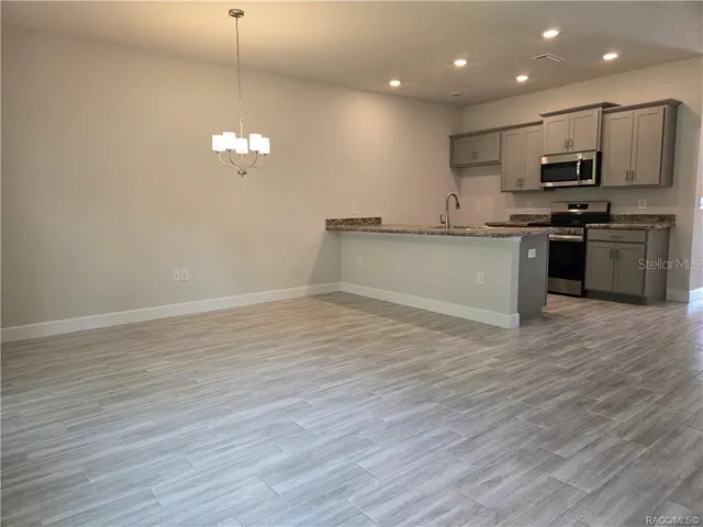 a view of kitchen with granite countertop cabinets and wooden floor