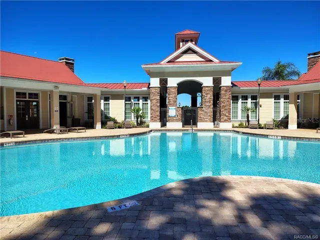 a view of a house with floor to ceiling windows and a table and chairs