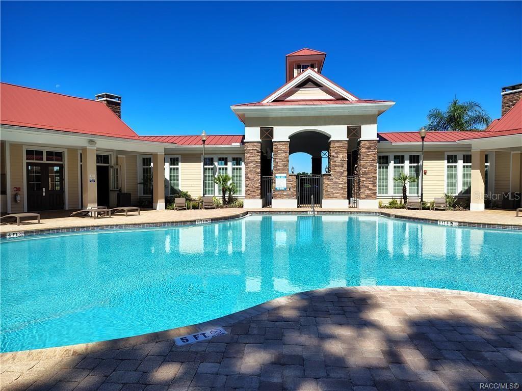 279 Bittern Loop Inverness, FL 34453 - Photo 24 of 30 a view of a house with floor to ceiling windows and a table and chairs