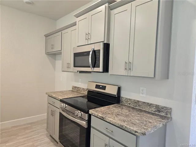 a kitchen with stainless steel appliances granite countertop a sink stove and microwave