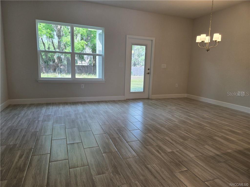 279 Bittern Loop Inverness, FL 34453 - Photo 5 of 30 a view of an empty room with wooden floor and a window