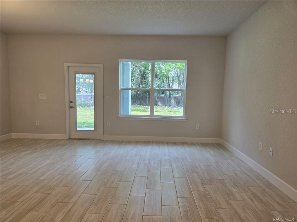 279 Bittern Loop Inverness, FL 34453 - Photo 6 of 30 an empty room with wooden floor and windows