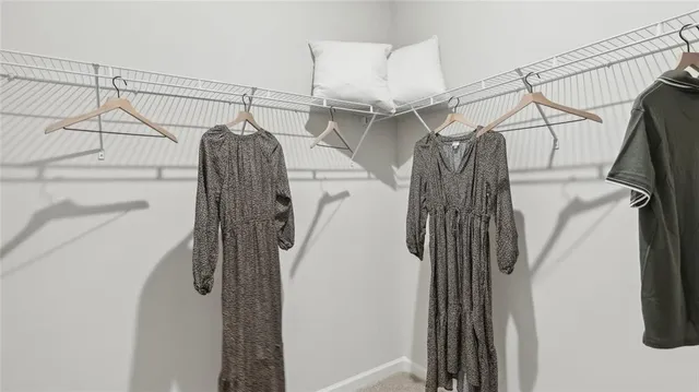 a view of walk in closet with clothes and shoes