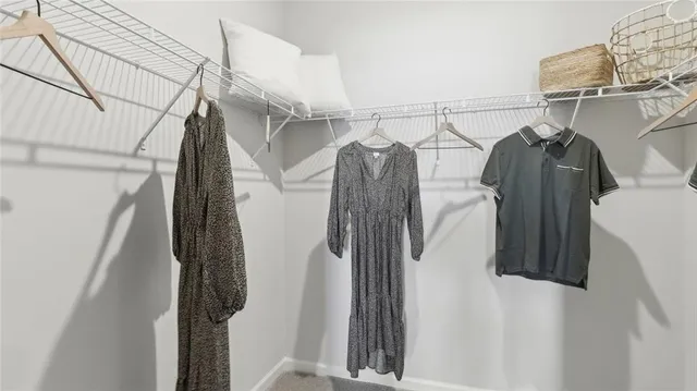 a view of walk in closet with clothes and shoes