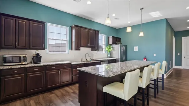 a kitchen with granite countertop a table chairs stove and cabinets