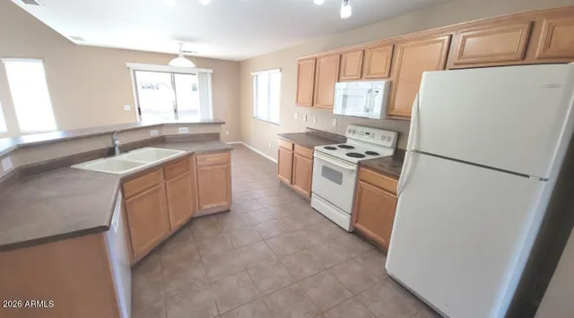a view of a kitchen with kitchen island a sink a counter top space and wooden floor