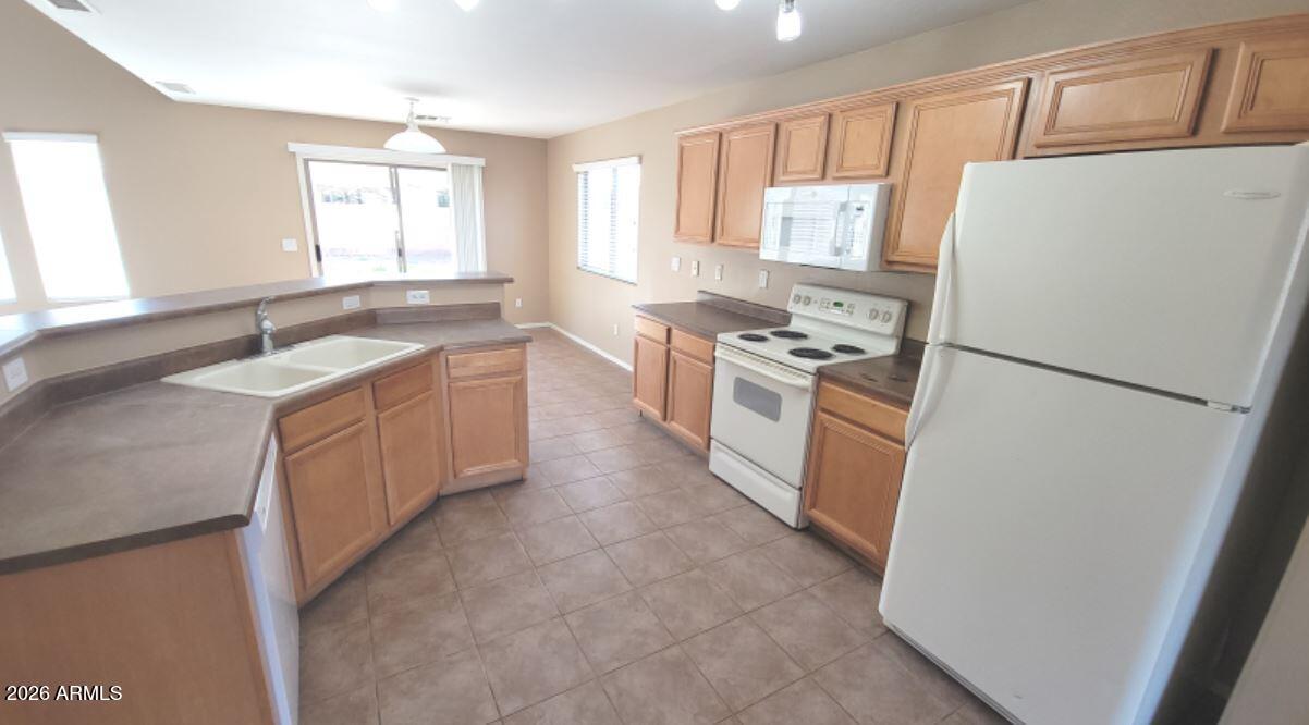 21821 East Via Del Rancho Queen Creek, AZ 85142 - Photo 12 of 35 a kitchen with a stove a refrigerator a sink and dishwasher