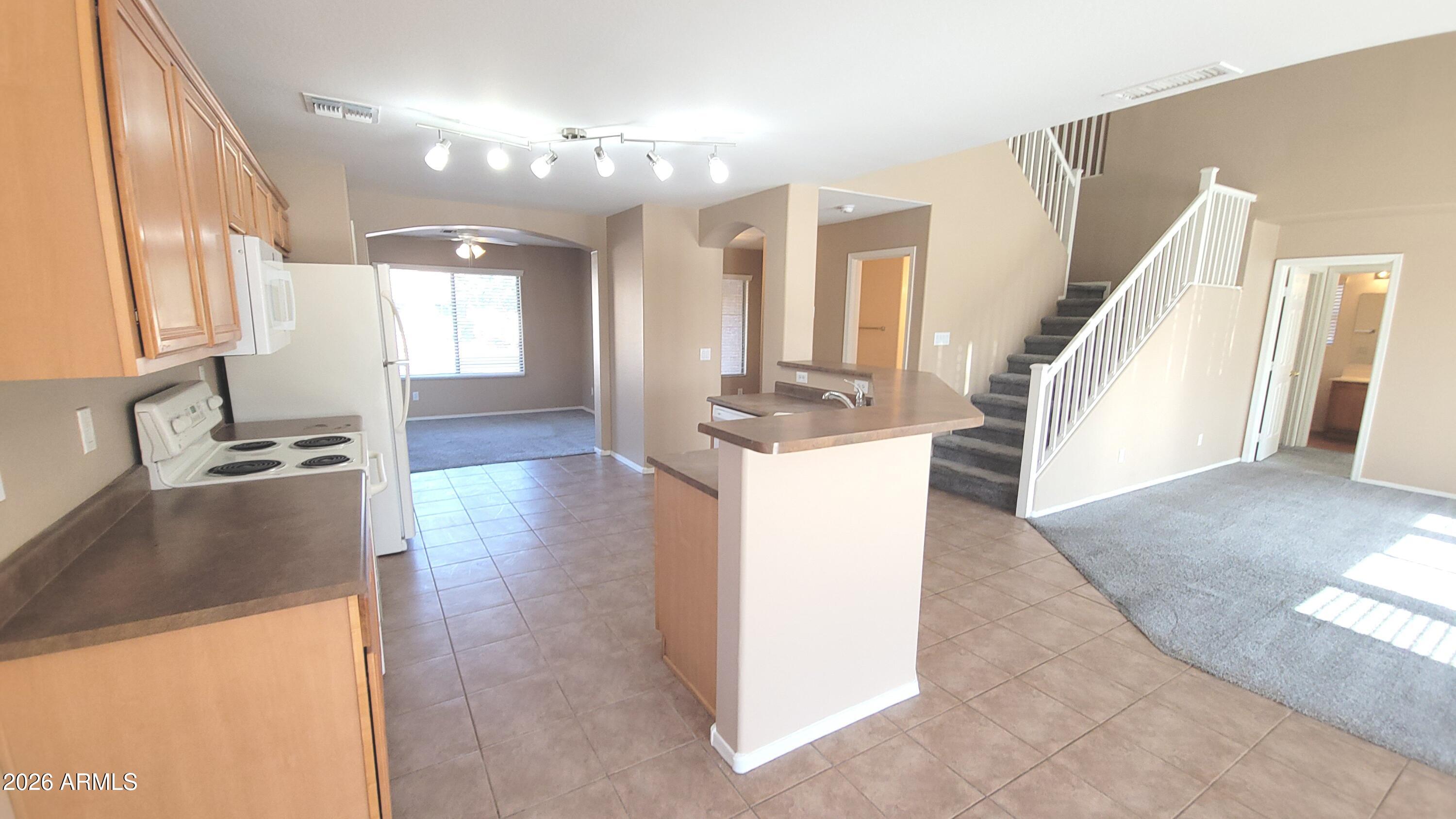 21821 East Via Del Rancho Queen Creek, AZ 85142 - Photo 13 of 35 a view of a kitchen with kitchen island a sink a counter top space and wooden floor