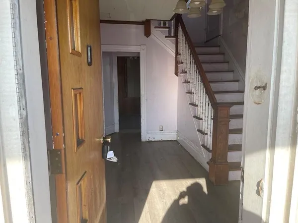 a view of entryway and hall with wooden floor