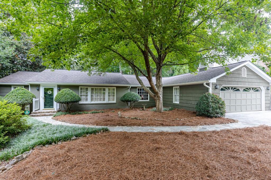 2740 Dover Road Northwest Atlanta, GA 30327 - Photo 1 of 1 a front view of a house with a garden and trees