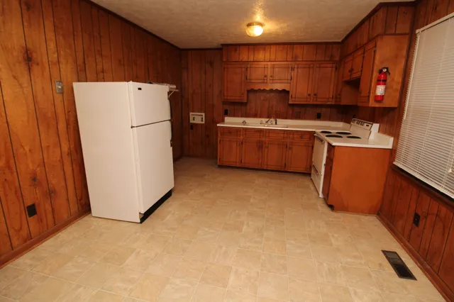 a kitchen with sink a refrigerator and a stove