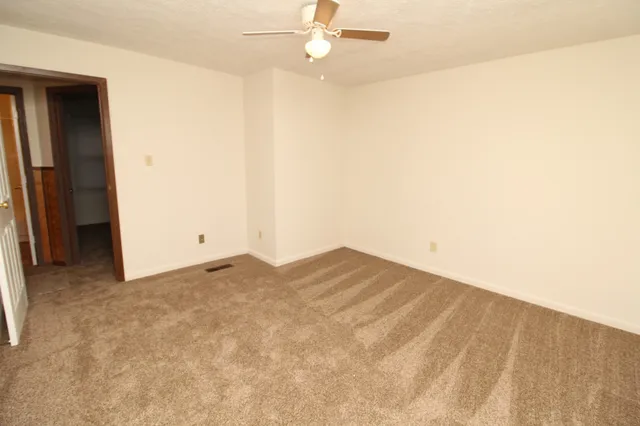 a view of empty room with ceiling fan