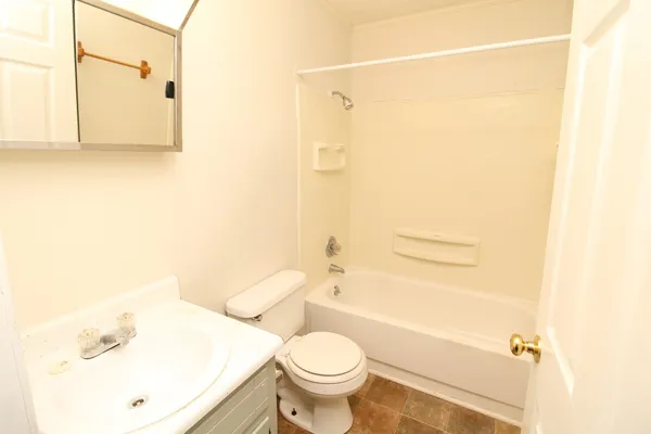 a white toilet sitting next to a bathroom sink and a shower