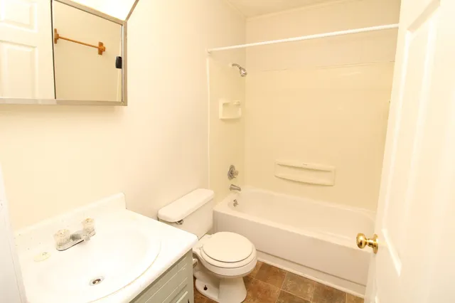 a white toilet sitting next to a bathroom sink and a shower