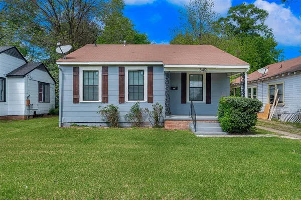 a view of a house with a yard and sitting area