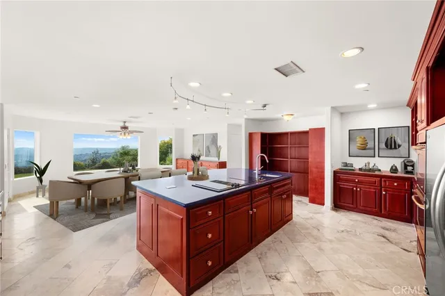 a kitchen with stainless steel appliances granite countertop a stove a sink dishwasher and a refrigerator with wooden cabinets