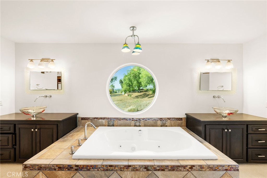 31460 Aquaduct Road Bonsall, CA 92003 - Photo 32 of 57 a bathroom with a granite countertop sink a mirror and bathtub