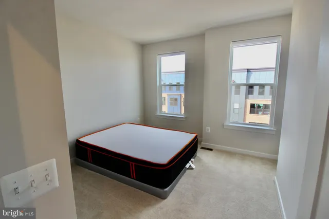 a room with a bed and two windows