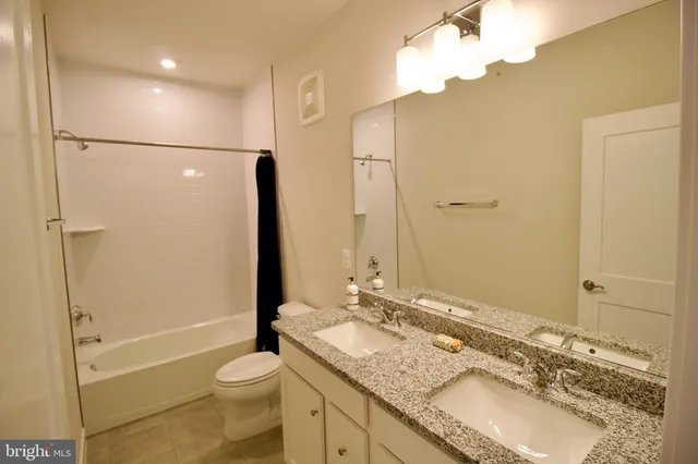 a bathroom with a granite countertop sink toilet and shower