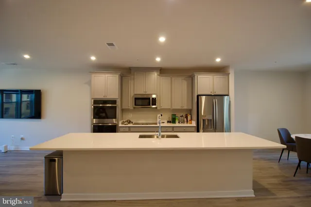 a kitchen with kitchen island a sink stainless steel appliances and cabinets
