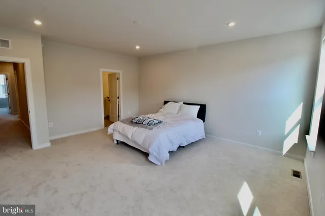 a bed sitting in a room next to a lamp