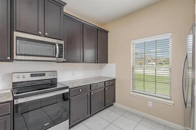 a kitchen with stainless steel appliances granite countertop a sink and dishwasher a stove top oven with wooden floor