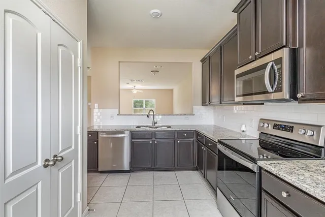 a kitchen with stainless steel appliances granite countertop a sink and dishwasher a stove top oven with wooden floor