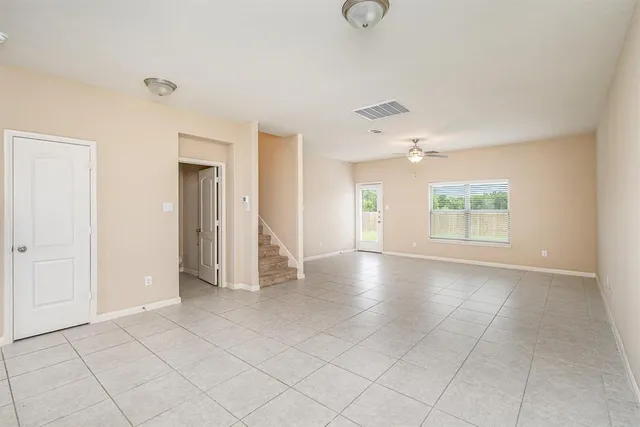 an empty room with fan and windows