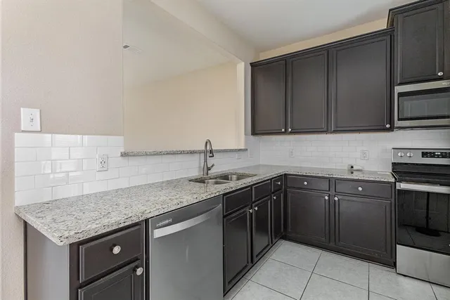 a kitchen with a stove sink and cabinets