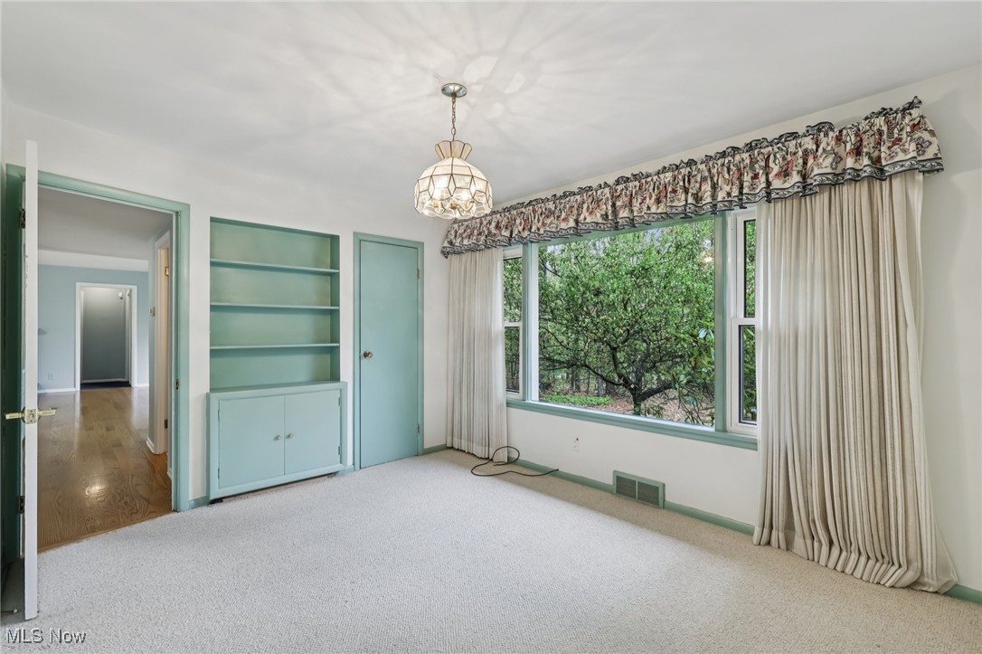 33300 South Woodland Road Cleveland, OH 44124 - Photo 29 of 50 Unfurnished dining area featuring carpet floors, a chandelier, and built in features