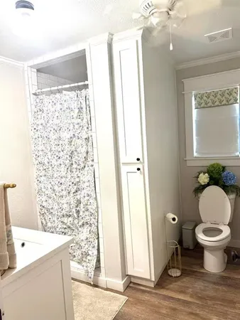 a bathroom with a granite countertop toilet a sink and a mirror