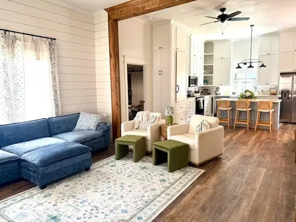 a living room with furniture wooden floor and a view of kitchen