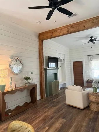 a living room with furniture and a wooden floor