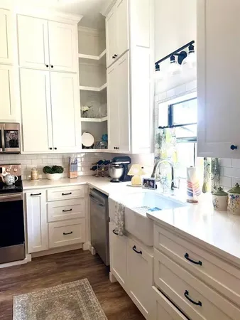 a kitchen with granite countertop white cabinets and white appliances