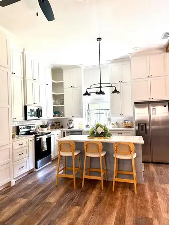a kitchen with appliances a counter space and chairs