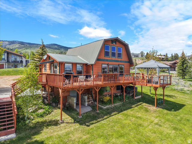371 Lewis Loop, Unit 29 Fish Haven, ID 83287 - Photo 5 of 40 Wood-sided residence featuring a gambrel roof and extensive wrap-around decking