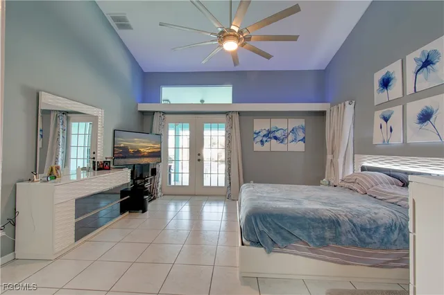 a bedroom with a large bed and a chandelier fan