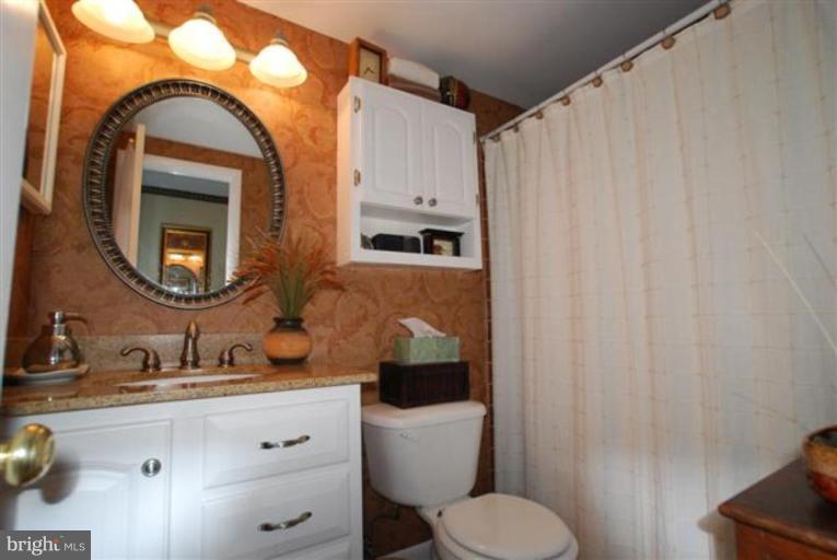 101 Cross Keys Road, Unit B Baltimore, MD 21210 - Photo 9 of 12 a bathroom with a toilet sink and mirror