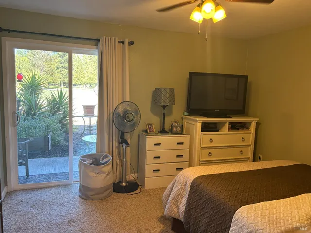 a bedroom with a bed and a flat tv screen on dresser
