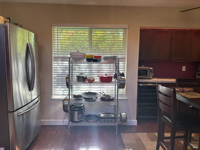 a kitchen with a refrigerator and wooden floor
