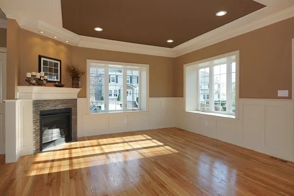 a view of empty room with wooden floor and fireplace