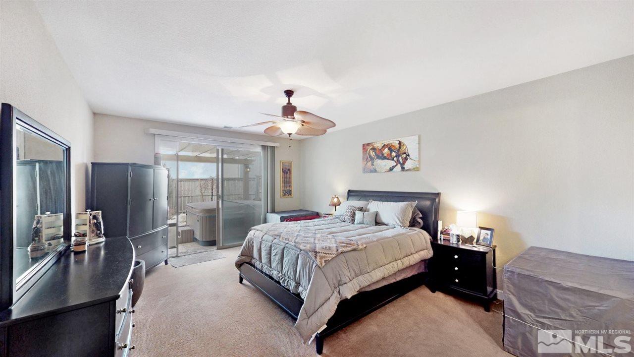 14095 Winners Cup Drive Reno, NV 89521 - Photo 11 of 23 a spacious bedroom with a bed and a chandelier