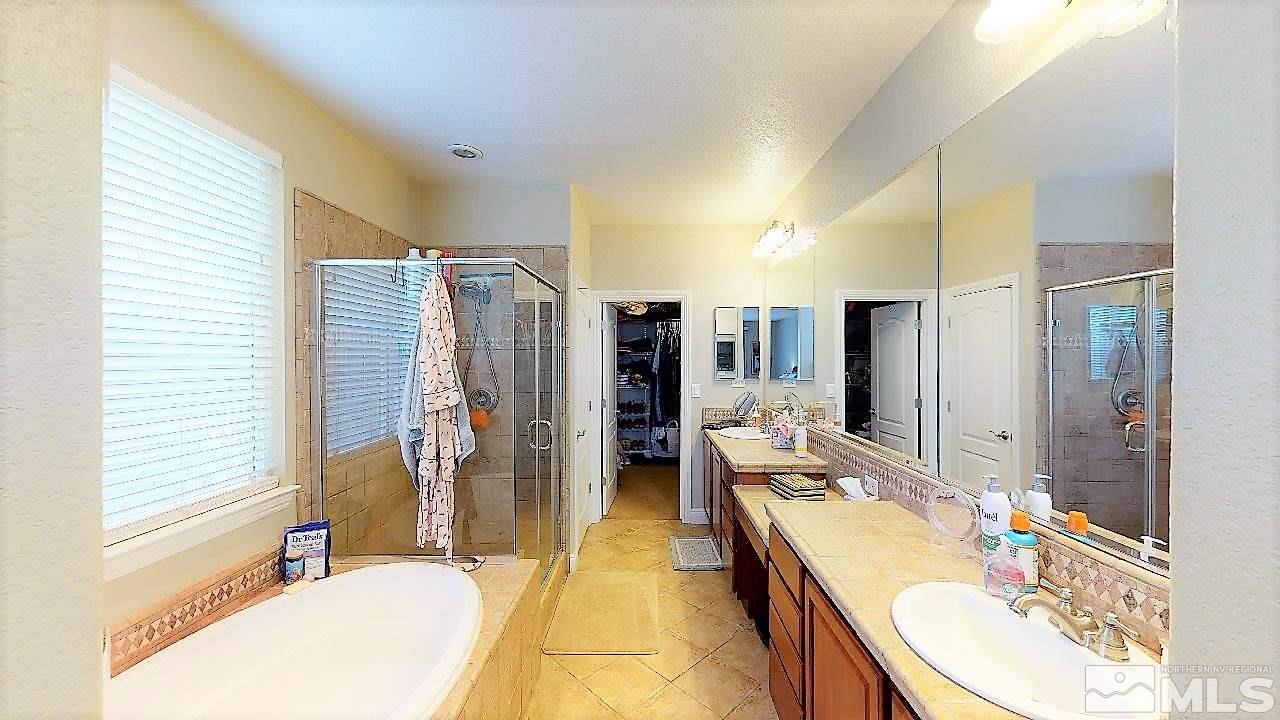 14095 Winners Cup Drive Reno, NV 89521 - Photo 13 of 23 a bathroom with a granite countertop sink mirror and a bathtub