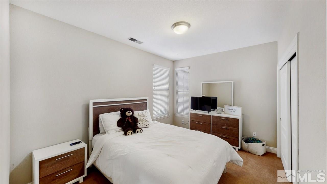 14095 Winners Cup Drive Reno, NV 89521 - Photo 14 of 23 a bedroom with a bed and a flat screen tv