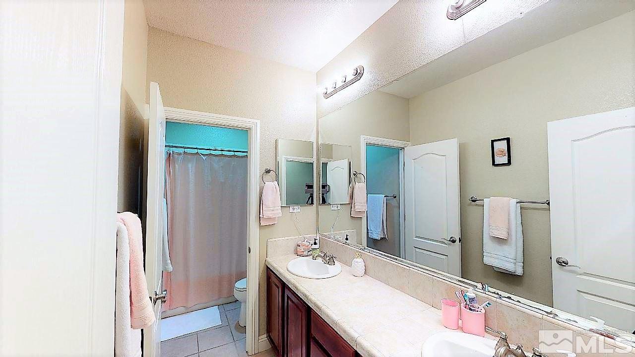 14095 Winners Cup Drive Reno, NV 89521 - Photo 15 of 23 a bathroom with a sink a mirror and a shower