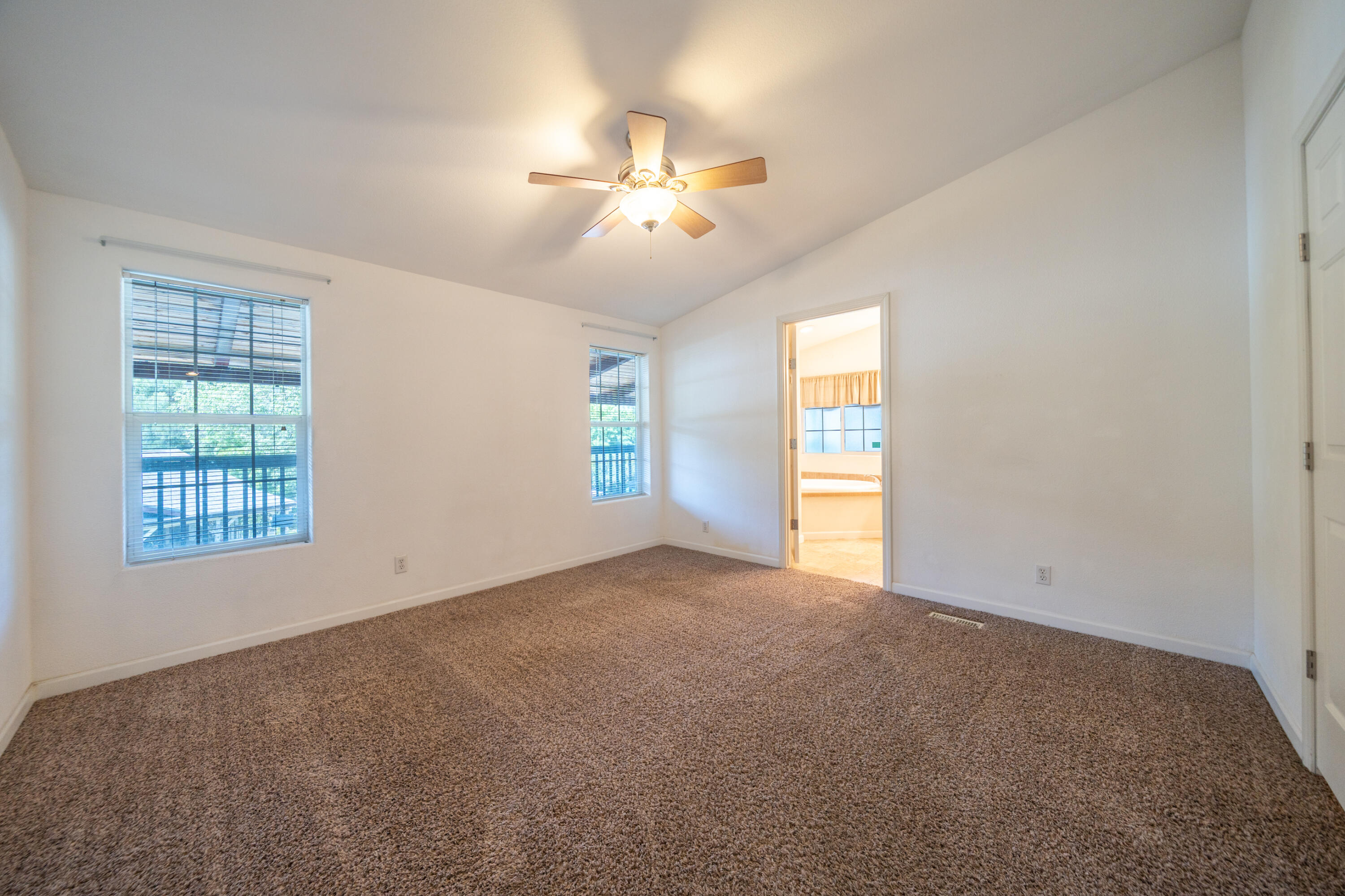 22151 Ravine Court Redding, CA 96003 - Photo 9 of 34 an empty room with windows and chandelier fan