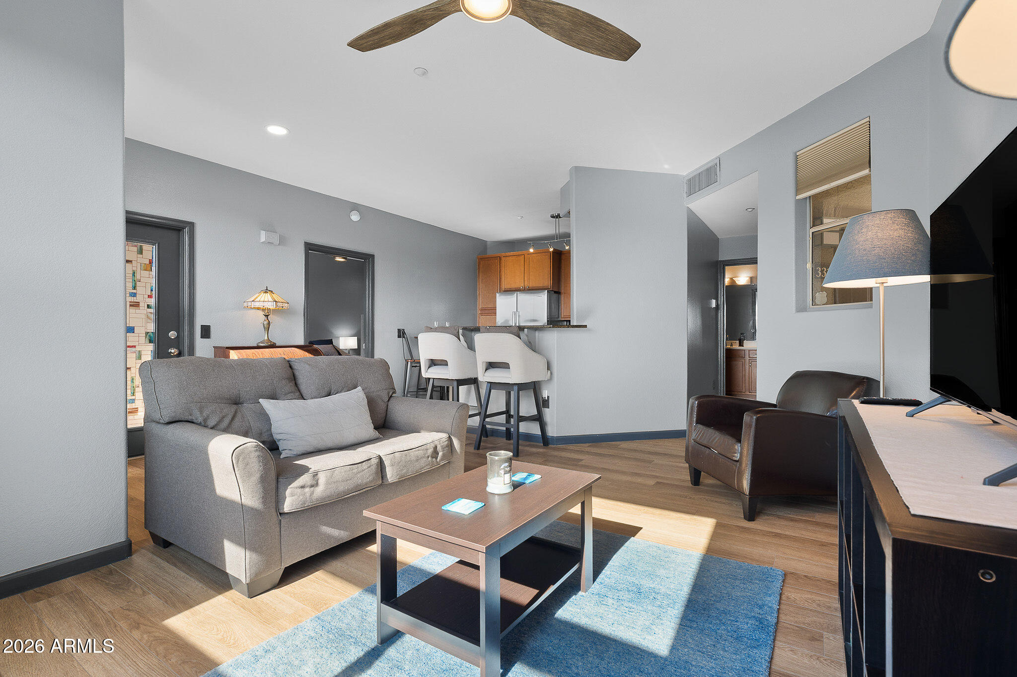 5303 North 7th Street, Unit 331 Phoenix, AZ 85014 - Photo 3 of 39 a living room with furniture a lamp and a flat screen tv
