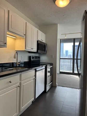 a kitchen with stainless steel appliances granite countertop a stove a sink and a microwave