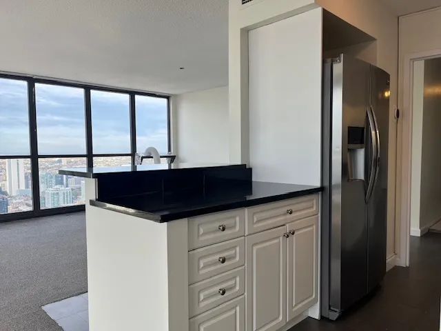 a kitchen with granite countertop a sink and a refrigerator