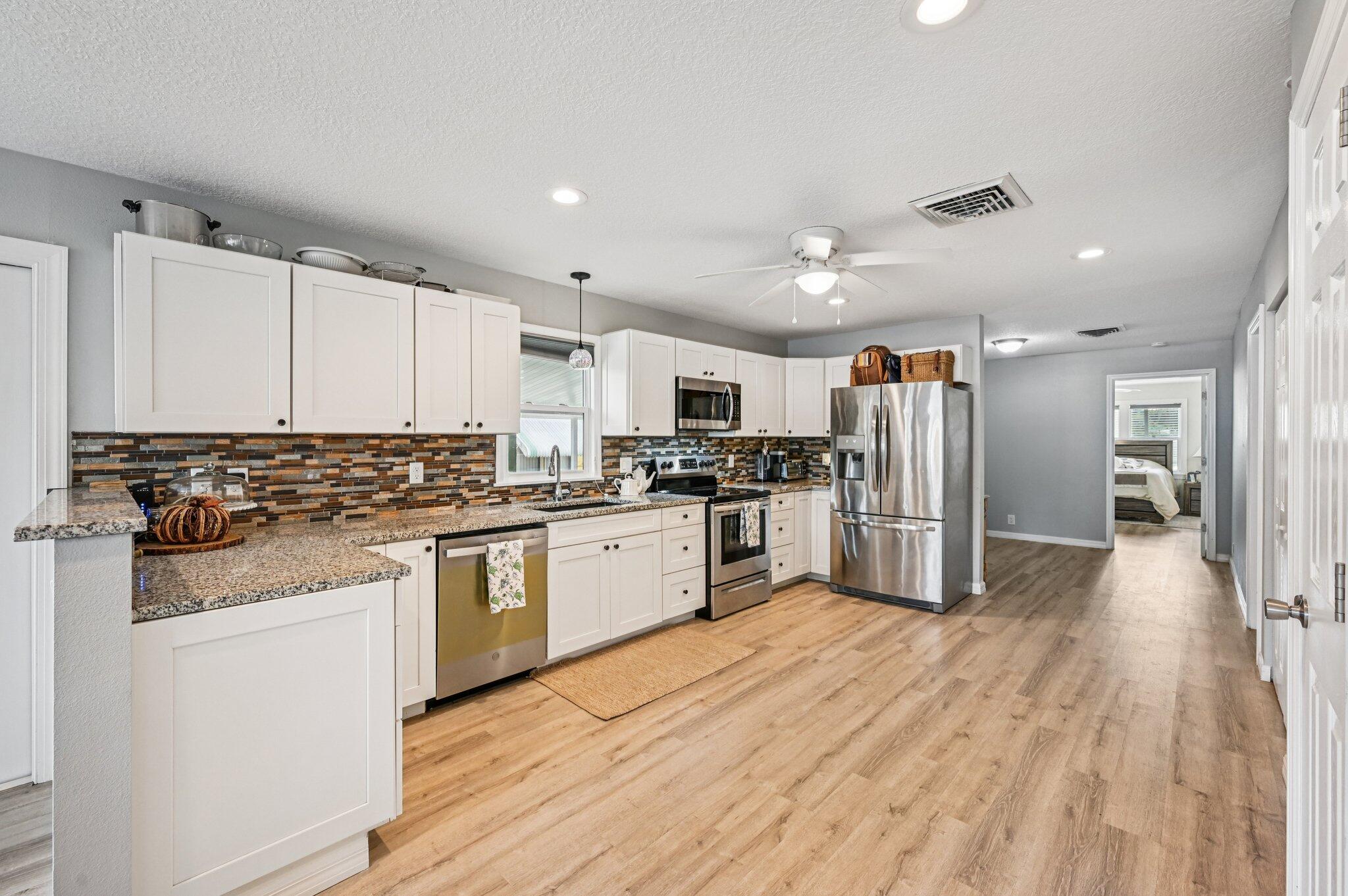 251 Southeast Paradise Place Stuart, FL 34997 - Photo 11 of 39 a kitchen with stainless steel appliances granite countertop a refrigerator and a stove top oven